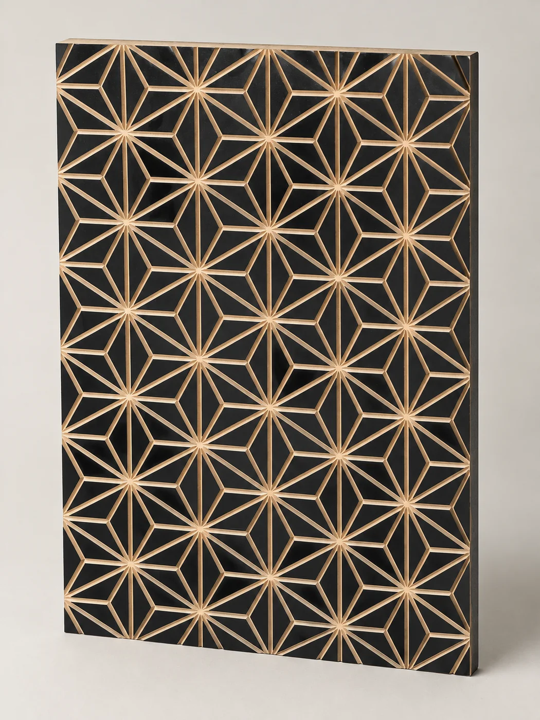 Black decorative panel with a geometric leaf-like pattern