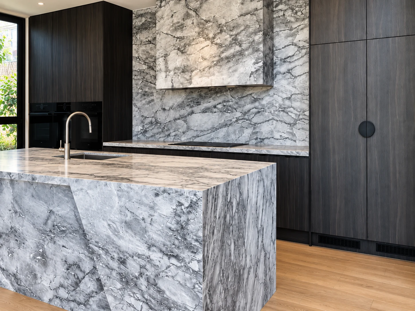 Charcoal cabinetry with a dramatic veined stone island and splashback