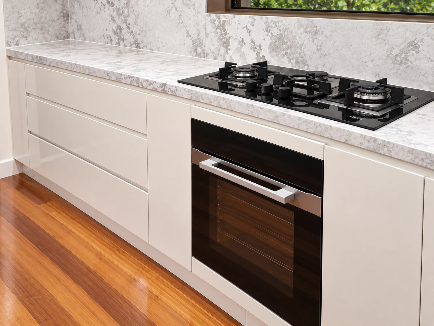 White handleless drawers with an integrated oven and gas cooktop