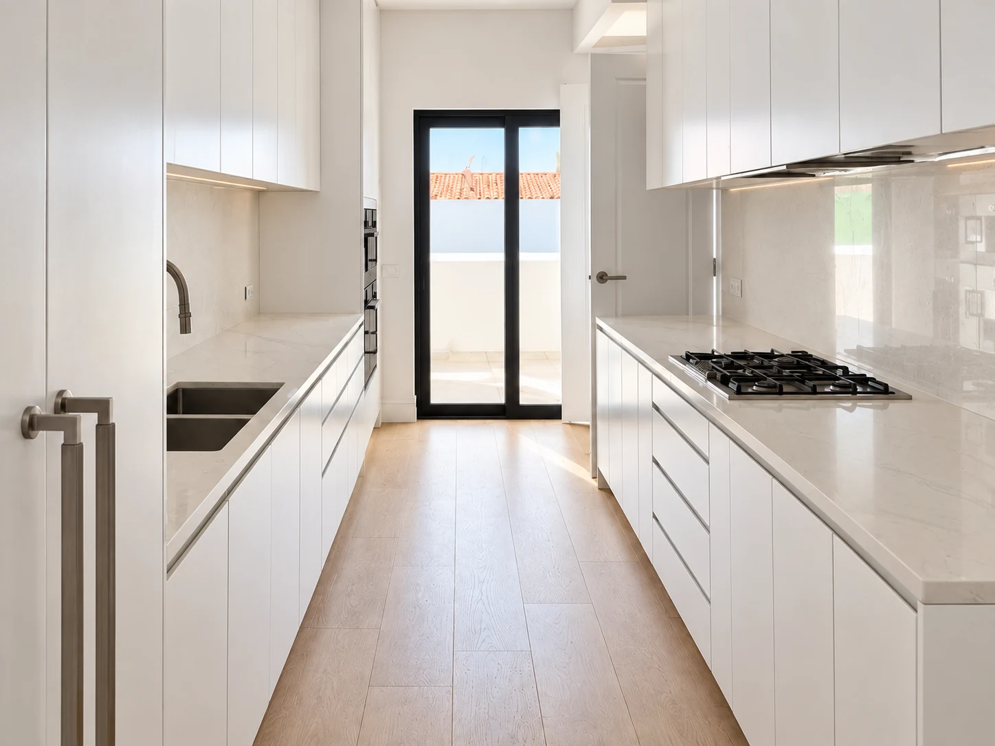 White galley kitchen with parallel cabinetry and black-framed garden doors
