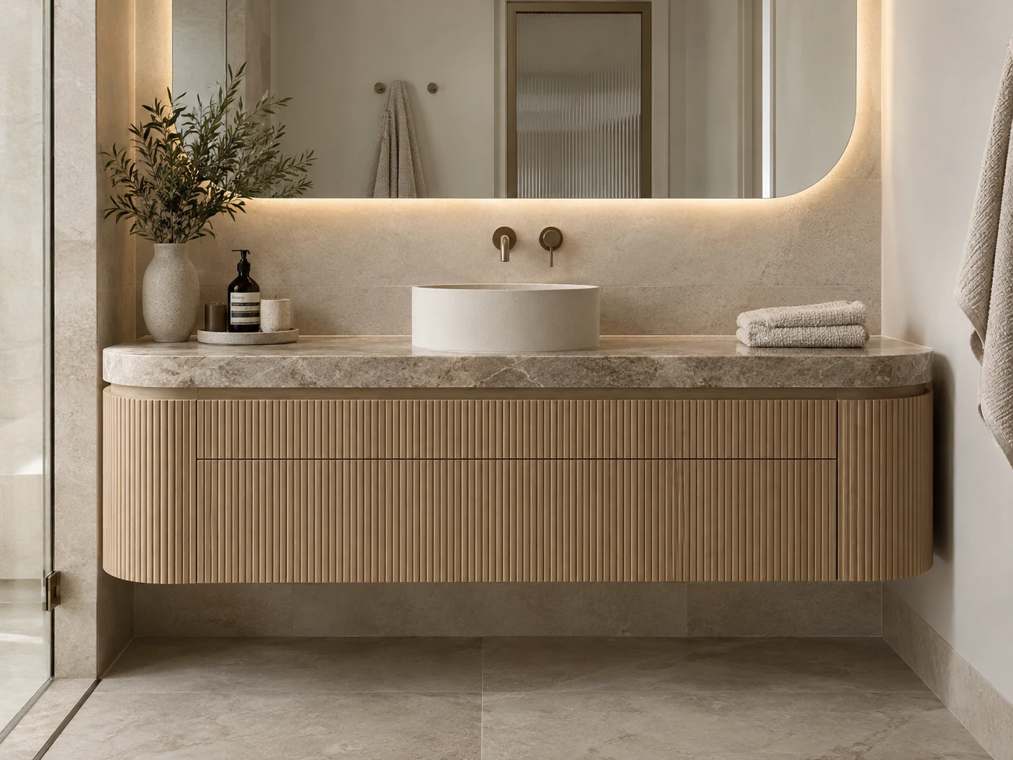 Rounded fluted oak vanity with a vessel basin and warm stone benchtop