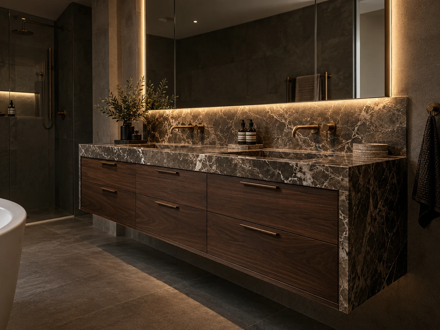 Floating walnut vanity with dark veined stone and a backlit mirror